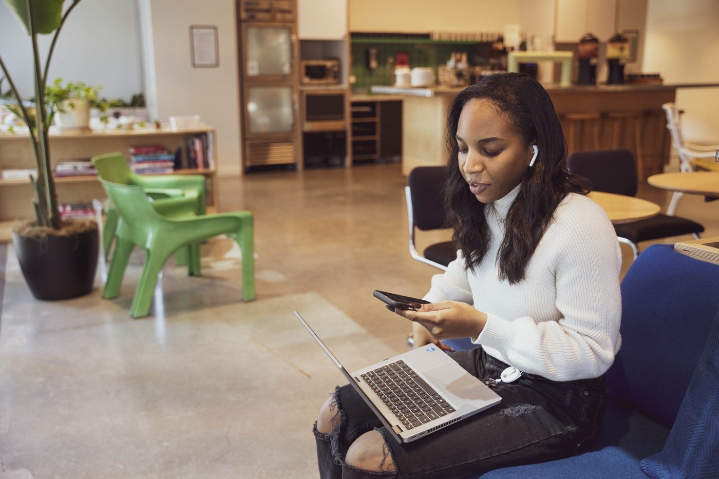 An engineer working on her laptop in a modern office lounge
